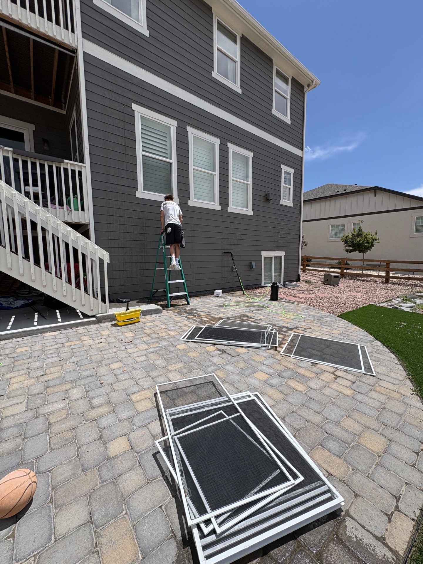 Red Wagon Windows team member working outside a large home with screens removed