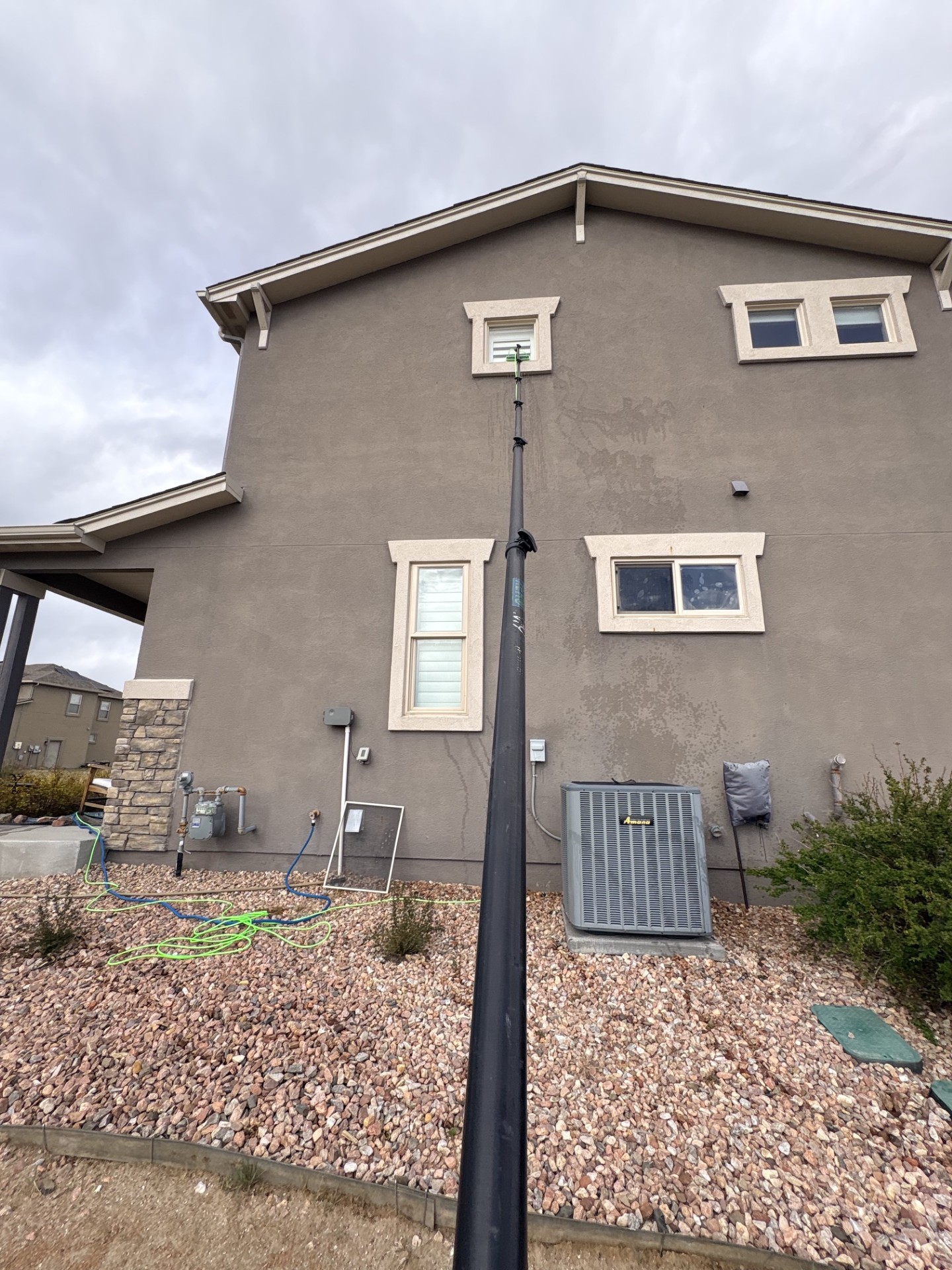 Exterior window cleaning with a water-fed pole on a tall home